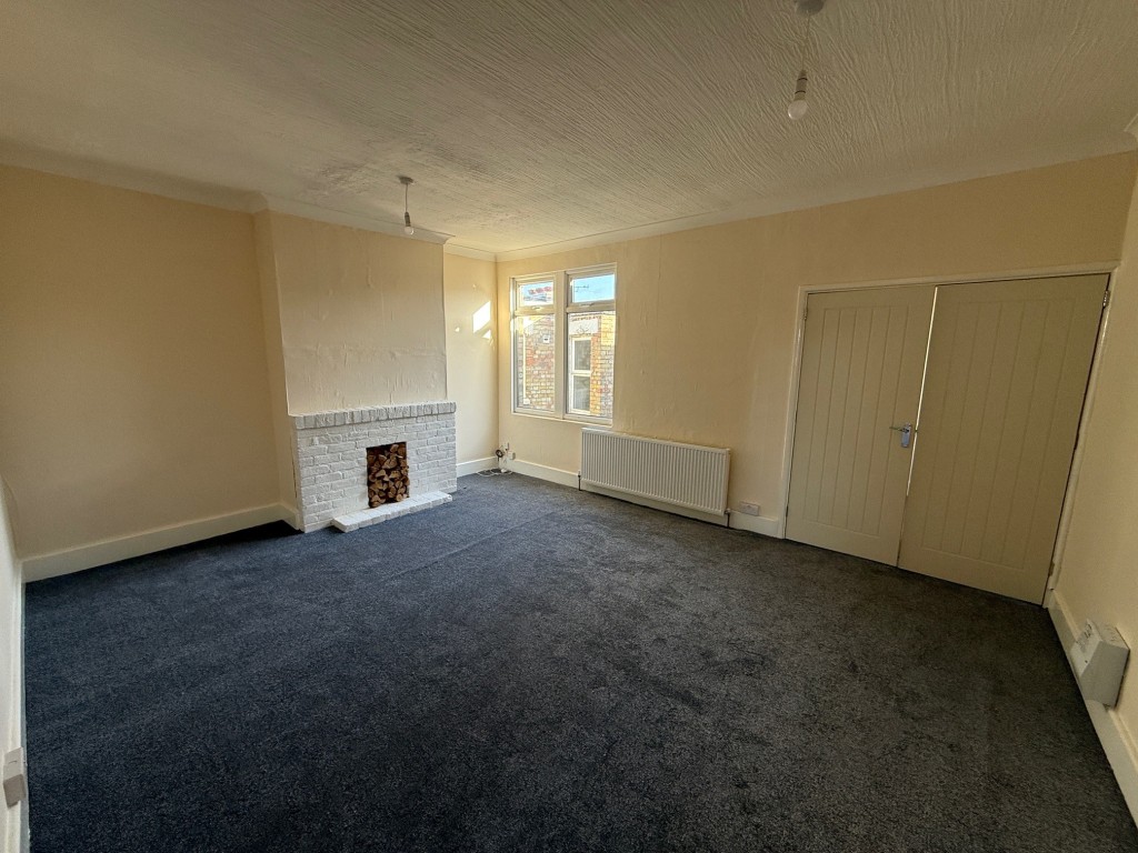 Lot: 63 - COMMERCIAL INVESTMENT WITH VACANT FLAT ABOVE - Living room with fireplace and widow to rear